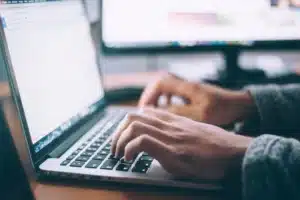 Booking online, hands on laptop keyboard