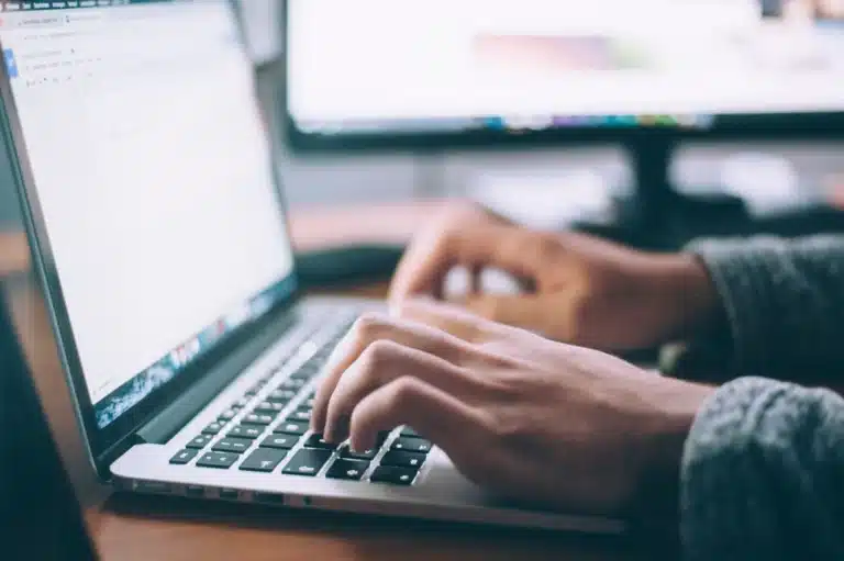 Booking online, hands on laptop keyboard